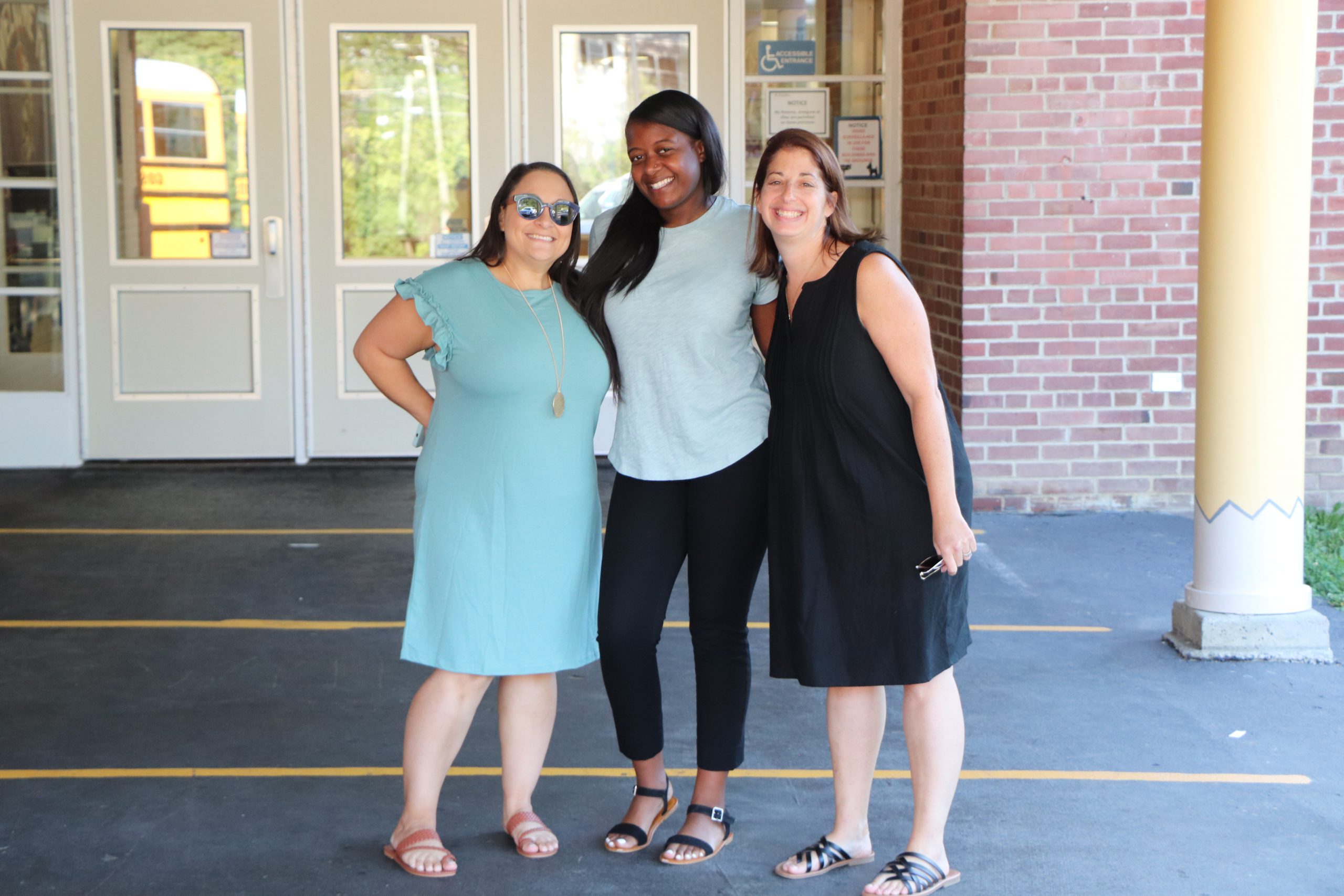 Three adults smile together.
