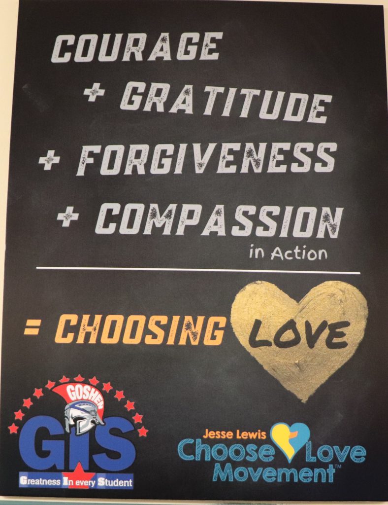 Image of a black poster that reads "Courage + Gratitude + Forgiveness + Compassion in Action = Choosing Love."