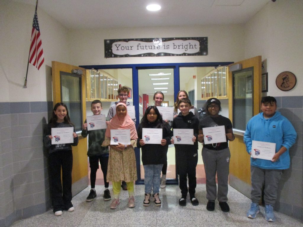Middle school students smile holding certificates in front of hallway doors with the text "Your future is bright" above them.