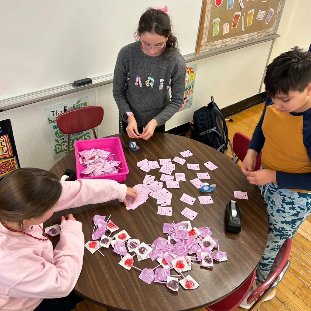 Middle school students pair Valentine's Day candy grams with lollipops.