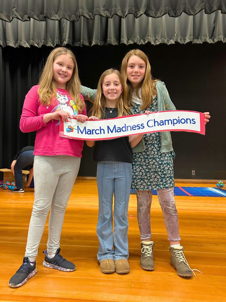 Josephine Cannella, Sophia De Venuto and Lea Galin hold up their March Madness Champions sign.