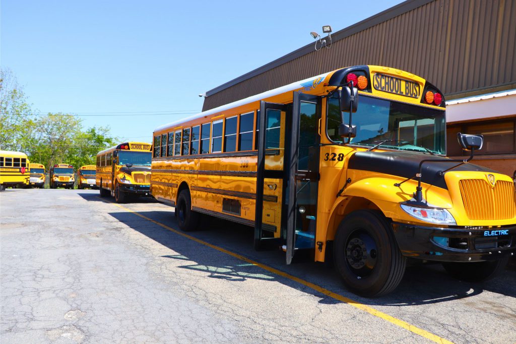 Both of Goshen's new electric buses are next to each other in the district garage parking lot.
