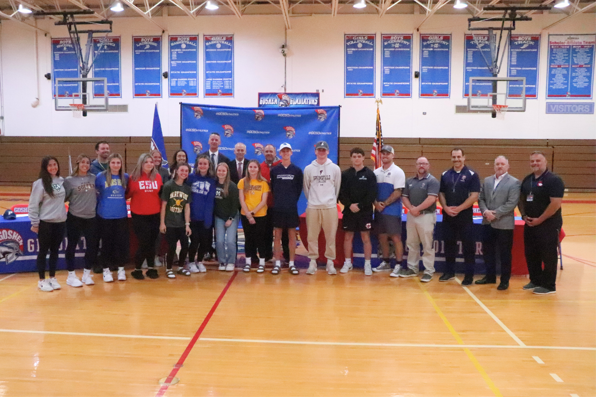 A group photo of all the athletes going to play college athletics with Goshen's Superintendent, High School Principal and assistant Principal, and Goshen's athletic director.