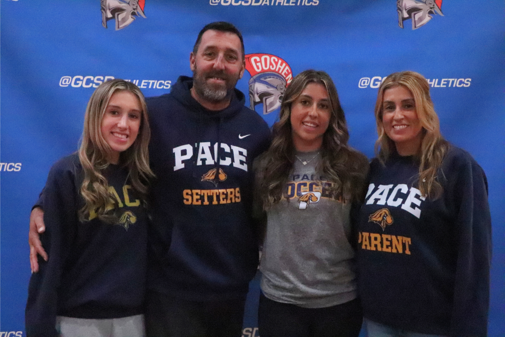 Julia Griffin smiles and looks at the camera with her family. They are all wearing Pace shirts and sweaters.