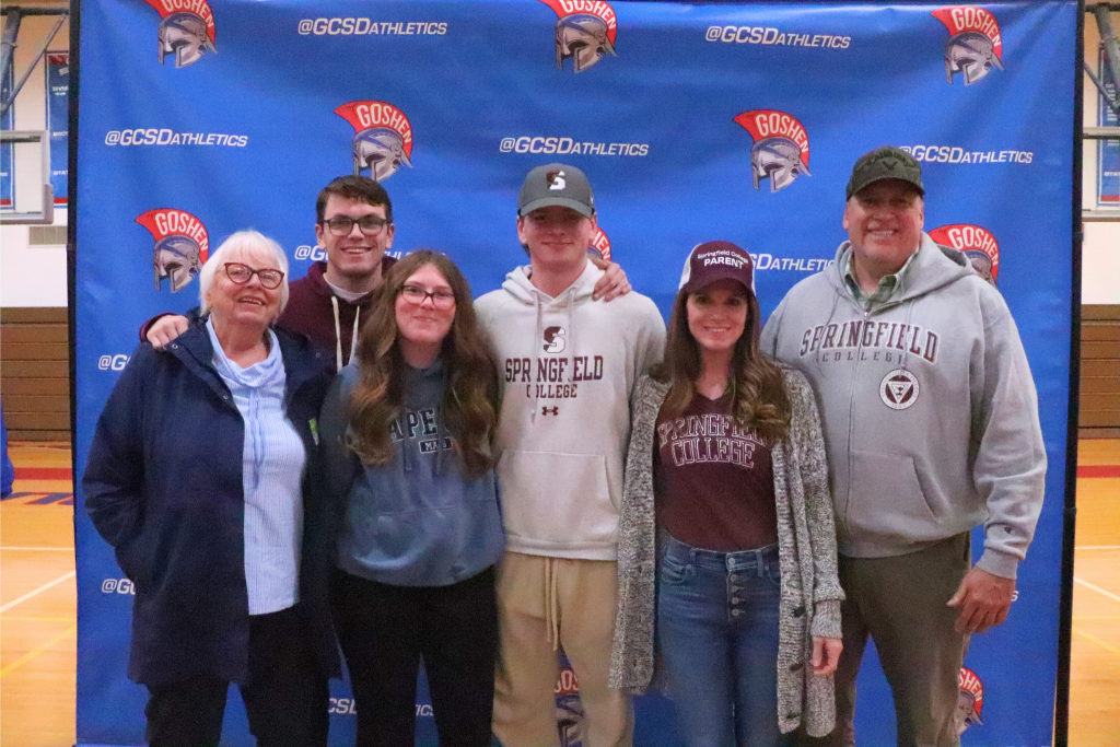 Colin Butryn stands and smiles with his family. There are three people to his right and two to his left. They are wearing Springfield shirts, hats and sweaters.