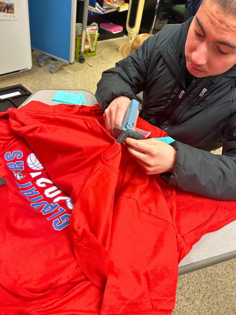 A student has a tool in his hands as he works on the Special Olympics shirts that are being created by Goshen's Kindness club.