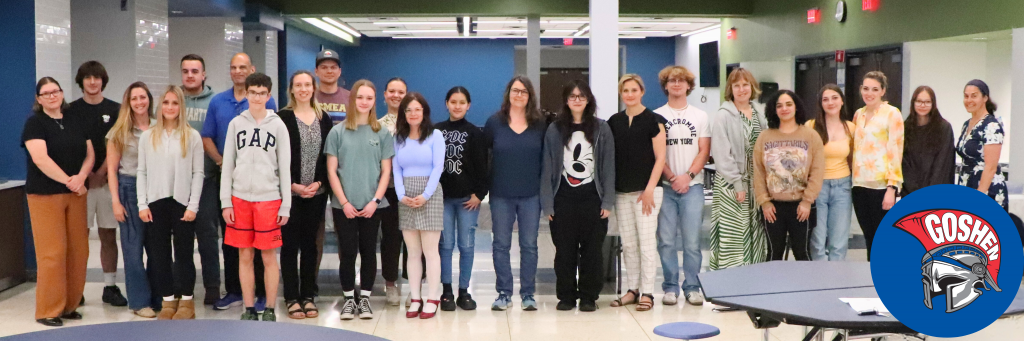 A group photo of all the students that were honored at the Goshen Greats breakfast stand with their teachers in the cafeteria.