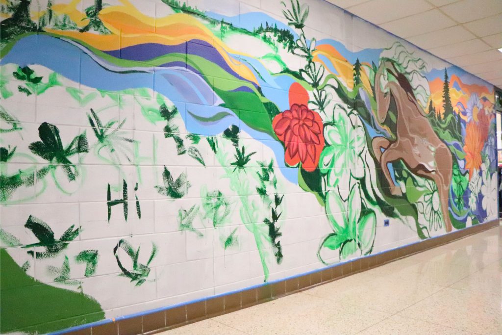 An unfinished wall has paint sketched out in places to be filled in on the wall in Goshen High School.