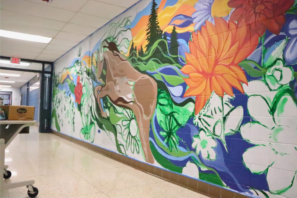 A side angle of the wall in Goshen High School that Katie Palau is painting on. The wall is unfinished but is painted in at many spots.