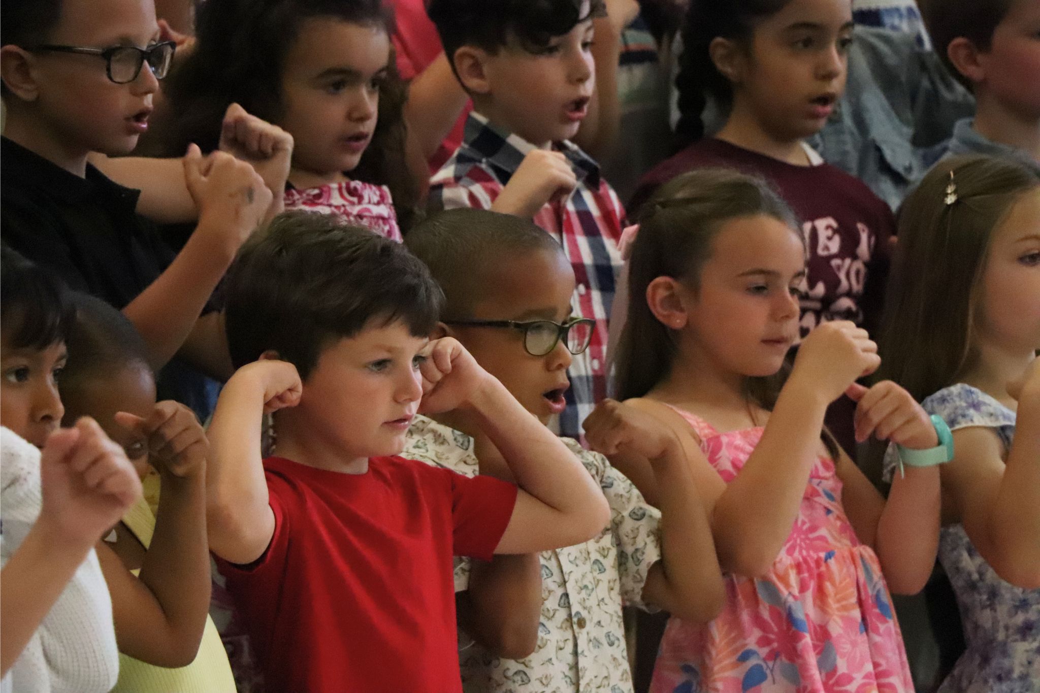 Students showing their muscles while performing on stage. 
