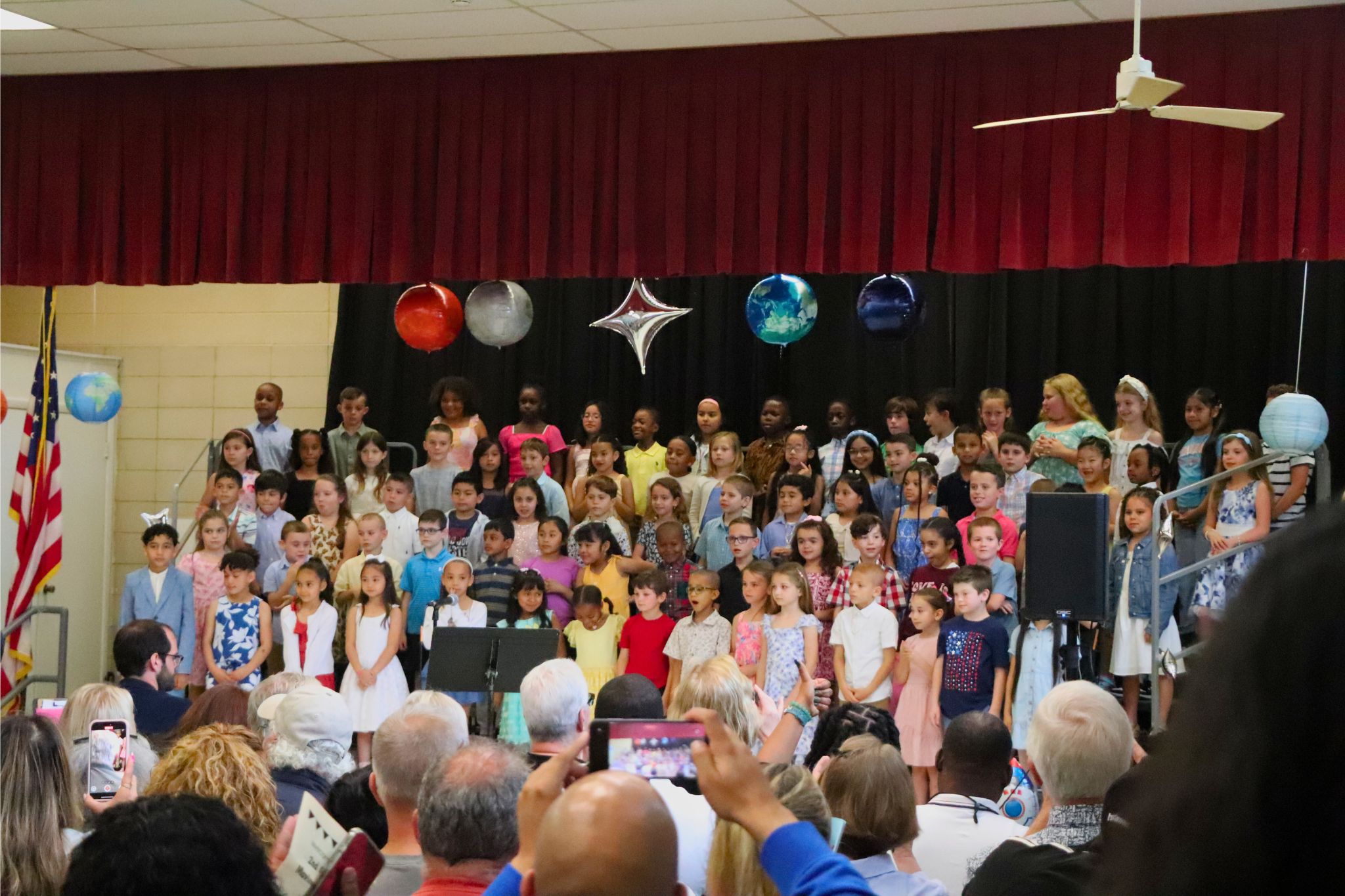 A wide shot of all the students on stage at the second grade moving up ceremony. 