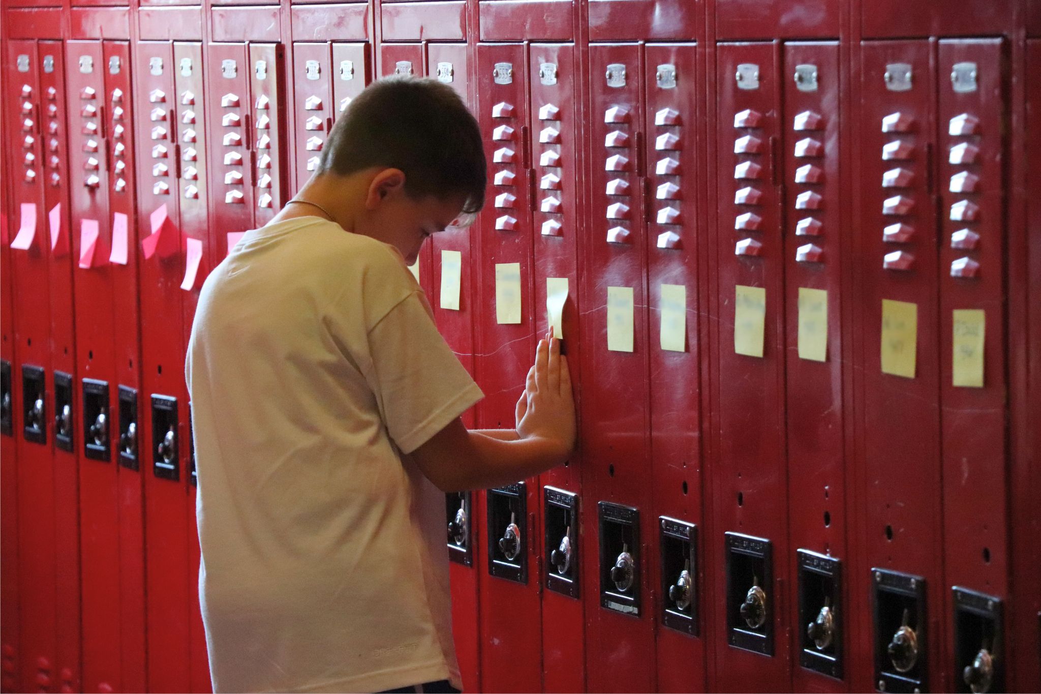 A student works on their locker on the first day of school. 