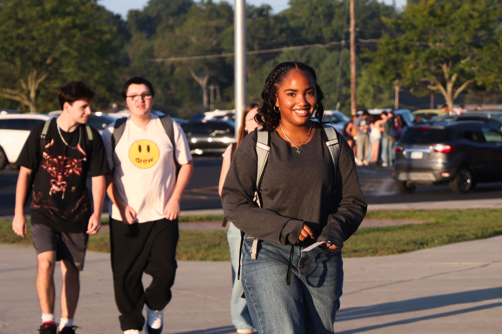 A student smiles on their way into school on the first day. 