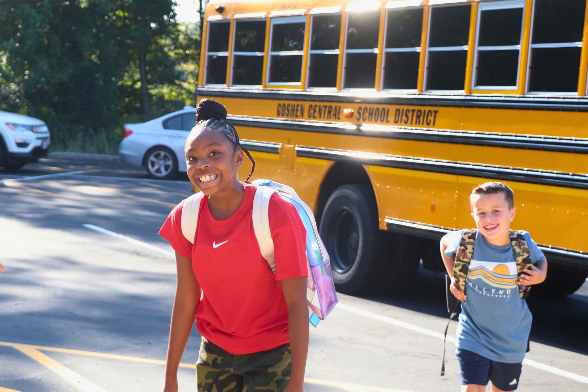 Two students walk off the bus on their way into school. 
