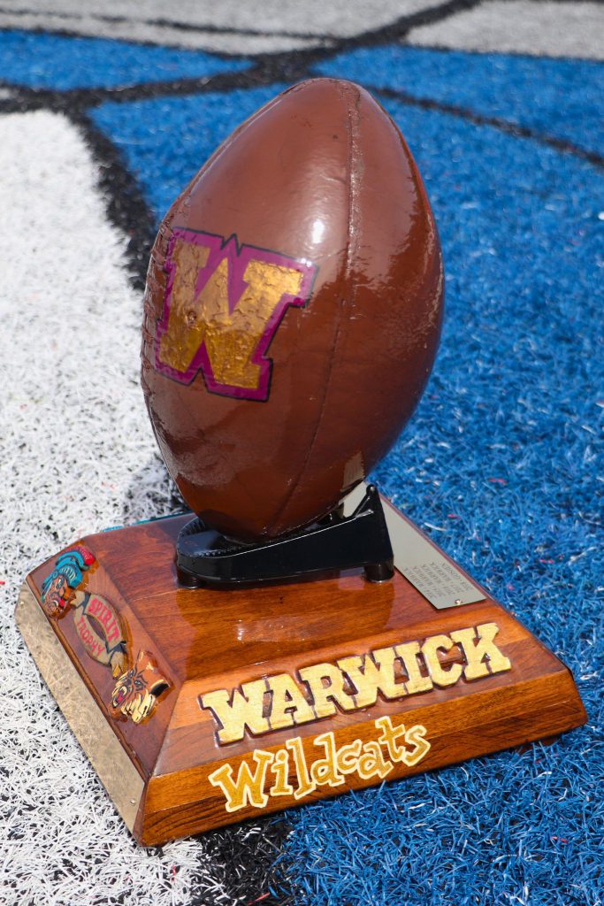 The right side of the trophy is the Warwick Wildcats, with the Warwick school name spelled out and a "W" in Warwick gold and purple. 