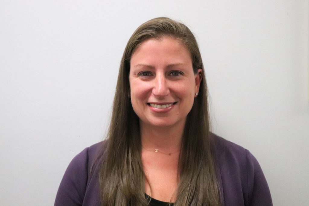 Doctor Erin Hyle smiles for a photo in front of a white background before being honored by the Mid-Hudson School Study Counsel.