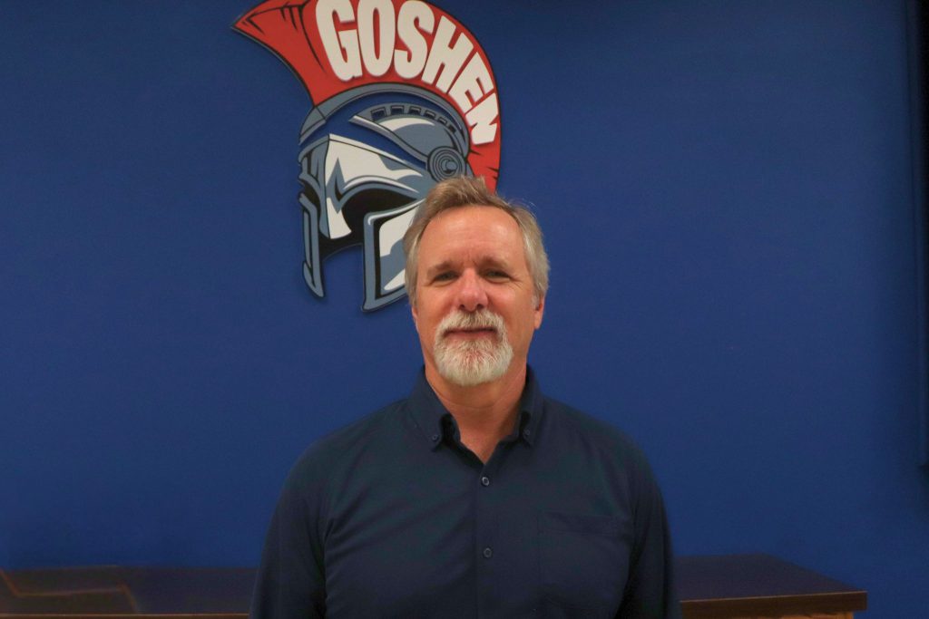 Jim Sterett smiles for a photo in front of a Goshen Gladiators helmet before being honored by the Mid-Hudson School Study Counsel.