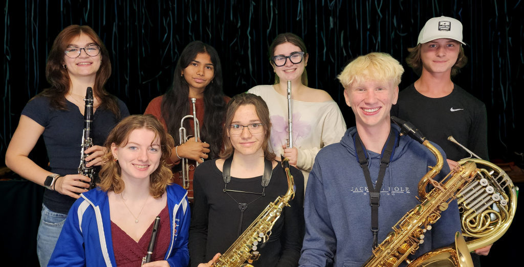 High school musicians smiling holding instruments