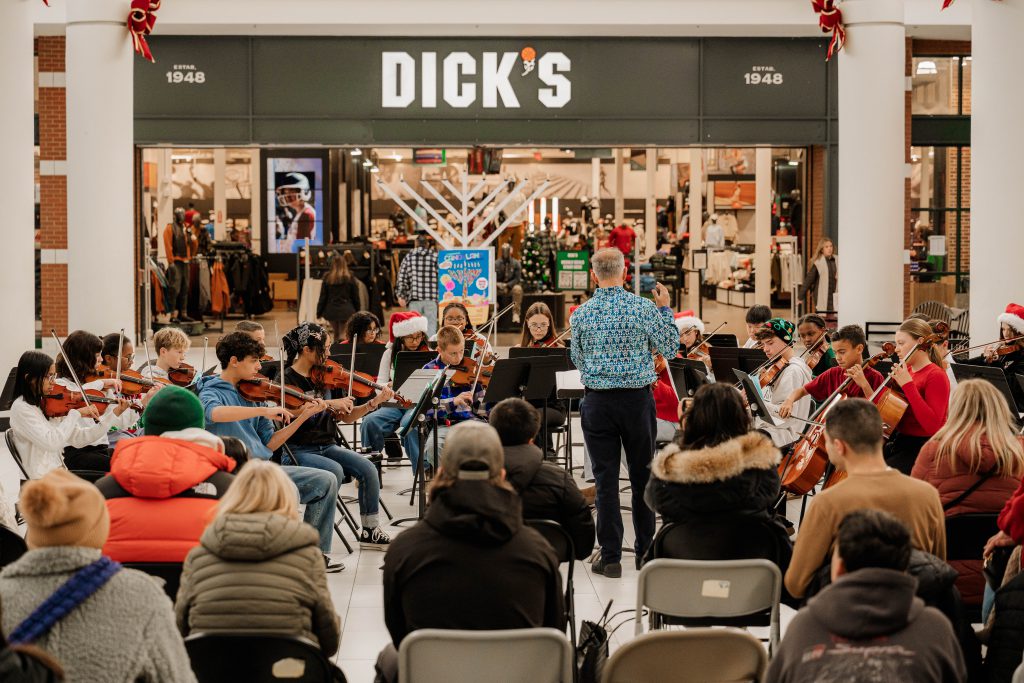 Orchestra students surround their director as they perform