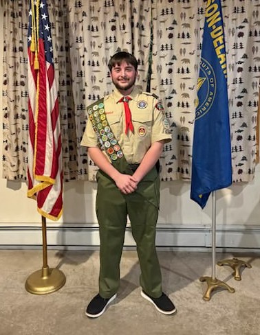 Teen in Boy Scout uniform smiling.