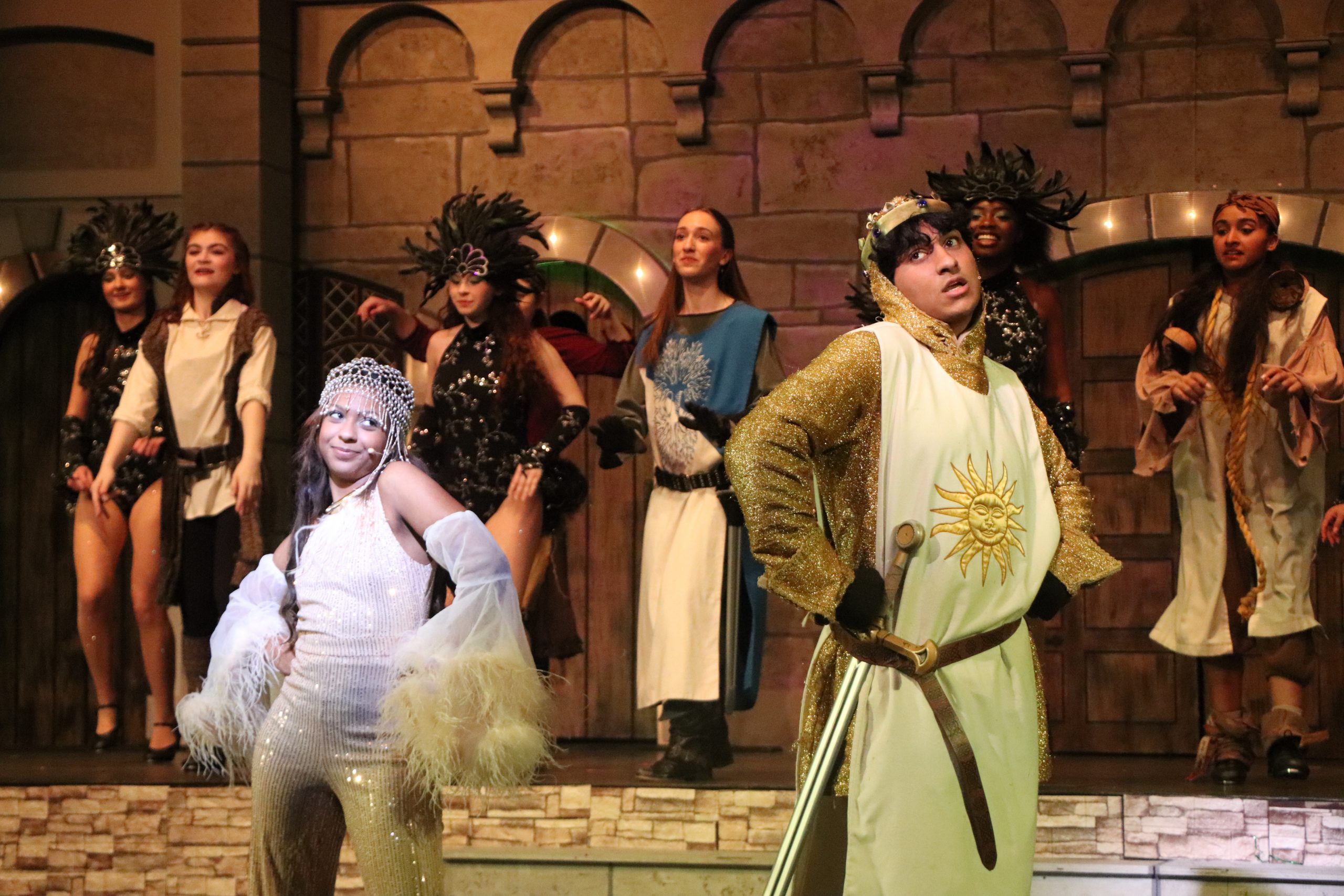 High school students wear red and stand behind a white table in the school lobby.
